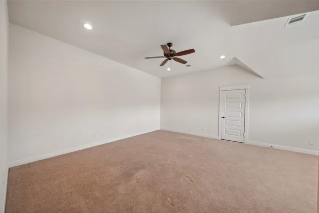 an empty room with a ceiling fan and a window