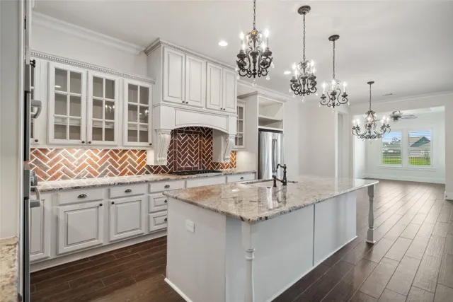 a kitchen with stainless steel appliances granite countertop a sink dishwasher a stove refrigerator and cabinets with wooden floor