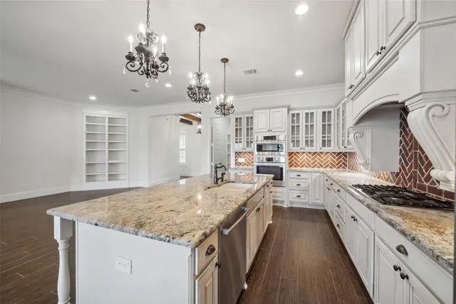 a kitchen with stainless steel appliances granite countertop sink stove and refrigerator