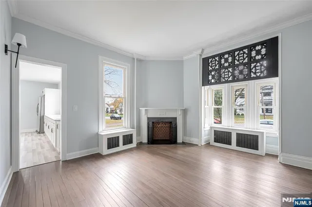 a view of a livingroom with wooden floor fireplace and windows