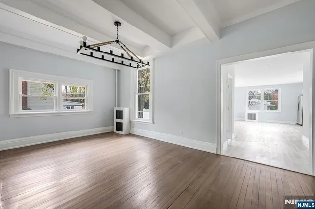 a view of a hallway with wooden floor and a window