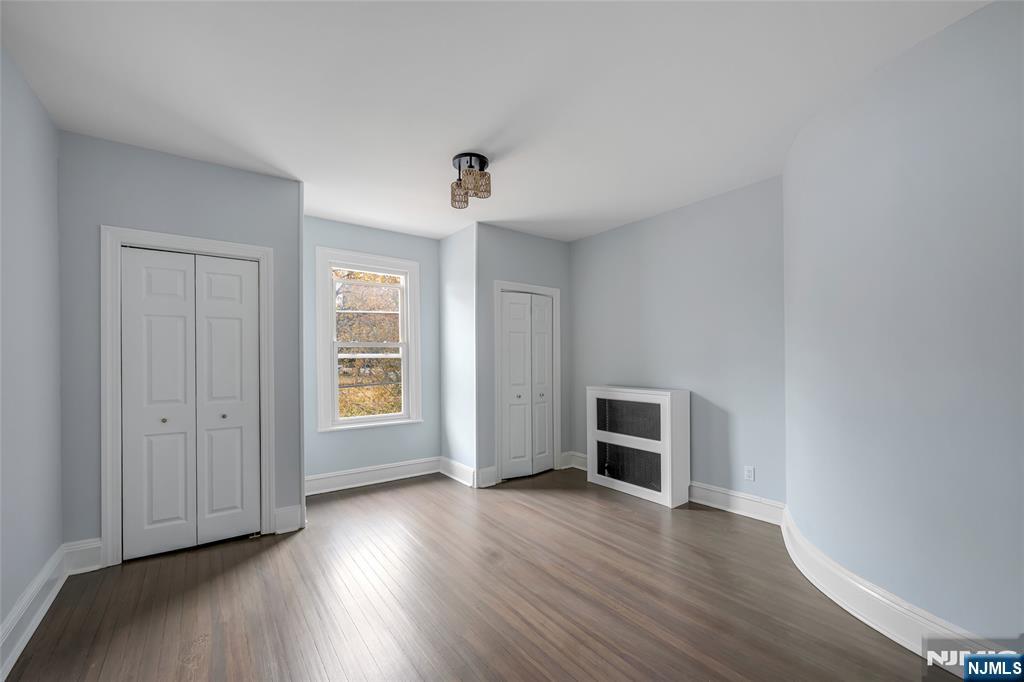 684 Closter Dock Road Closter, NJ 07624 - Photo 23 of 30 an empty room with wooden floor fireplace and windows