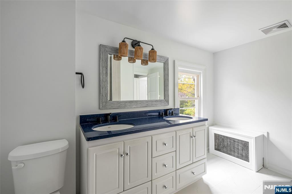 684 Closter Dock Road Closter, NJ 07624 - Photo 25 of 30 a bathroom with a granite countertop sink and a mirror