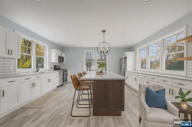 a large kitchen with a lot of window and wooden floor
