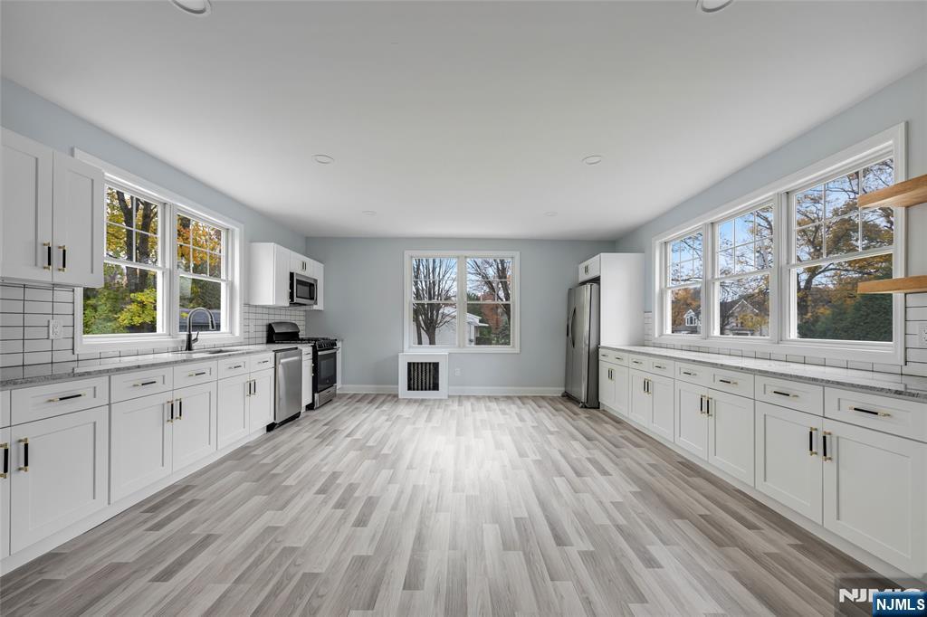 684 Closter Dock Road Closter, NJ 07624 - Photo 7 of 30 a large kitchen with a lot of window and wooden floor