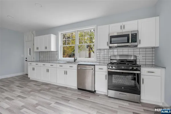 a kitchen with white cabinets stainless steel appliances and sink