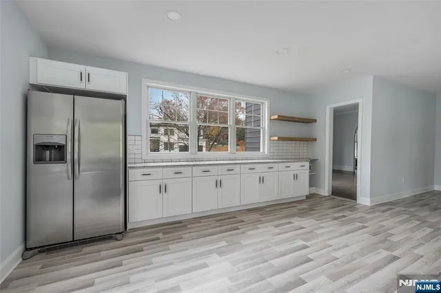 wooden floor fireplace and windows in an empty room