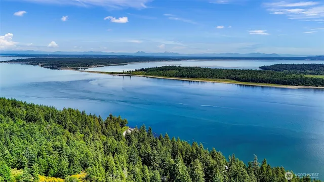 a view of a room with wooden floor and lake in the back