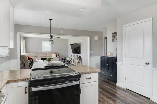 a kitchen with a stove and a wooden floor