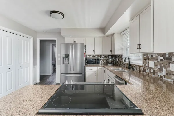 a kitchen with a refrigerator sink and cabinets