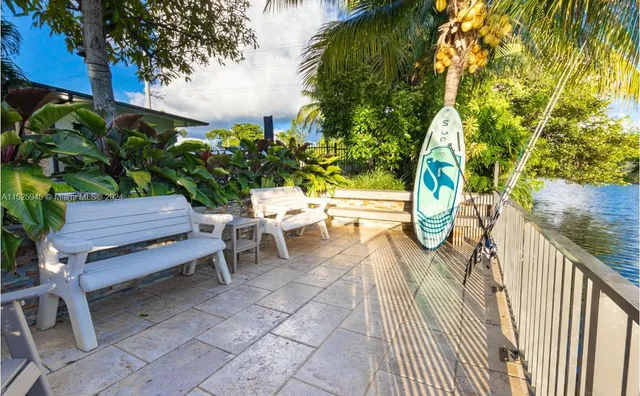a view of a patio with couches table and chairs and potted plants