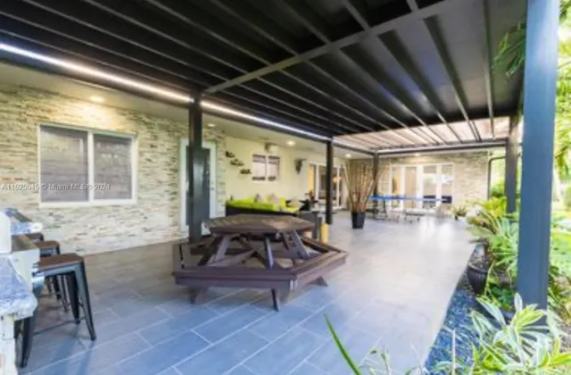 a front view of a house with a yard and potted plants