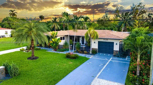 a view of house with garden and tall tree