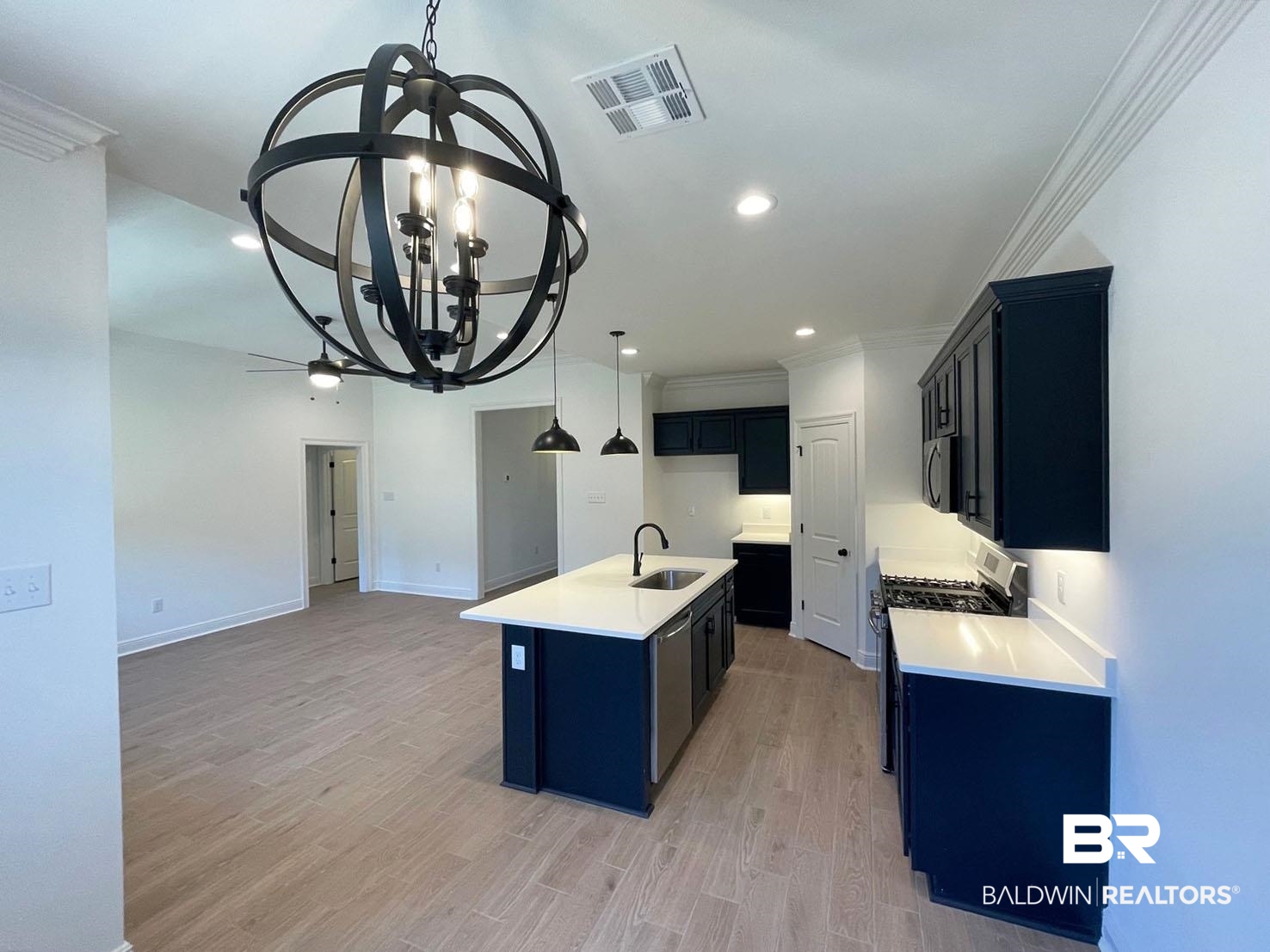 1396 Fenton Circle Foley, AL 36535 - Photo 4 of 14 Kitchen with light hardwood / wood-style floors, appliances with stainless steel finishes, a kitchen island with sink, a chandelier, and sink