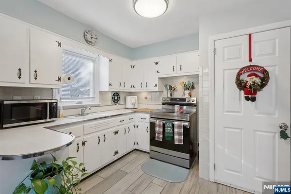 a kitchen with stainless steel appliances granite countertop a stove a sink and a white cabinets