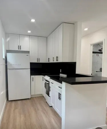 a kitchen with stainless steel appliances a refrigerator sink and white cabinets