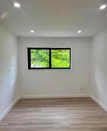 a view of a room with wooden floor and bench