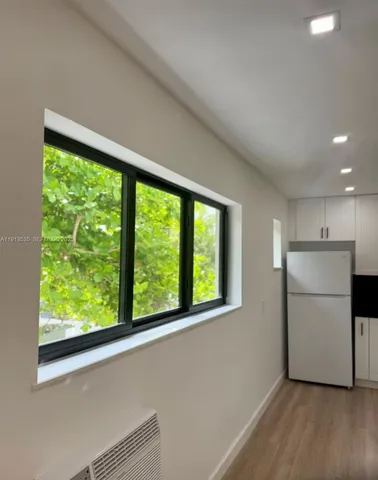 a view of kitchen with stainless steel appliances granite countertop a stove a microwave and a refrigerator