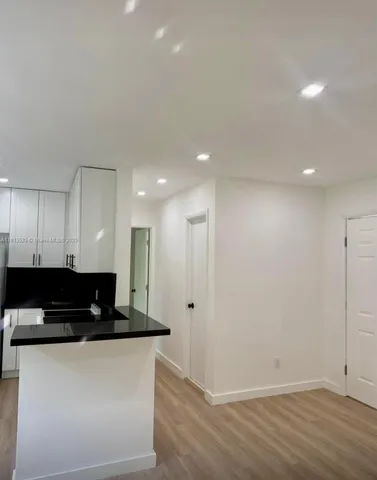 a view of a kitchen with a sink and a refrigerator
