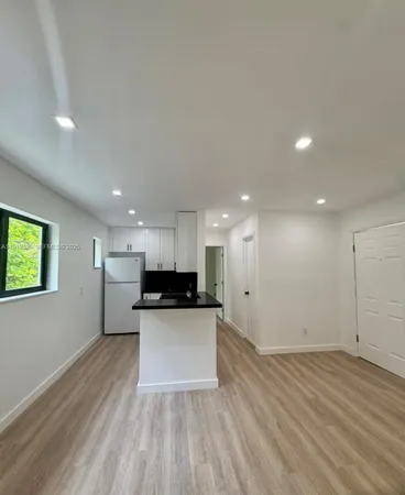 a view of kitchen with stainless steel appliances granite countertop cabinets and a wooden floor