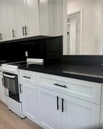 a view of a hallway with wooden floor and a bathroom