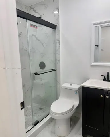 a bathroom with a sink vanity and toilet
