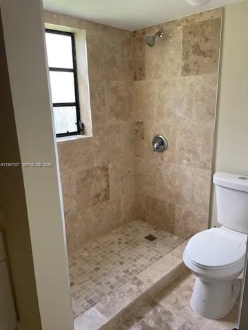 a bathroom with a toilet and a shower