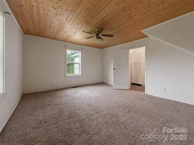 an empty room with windows and ceiling fan