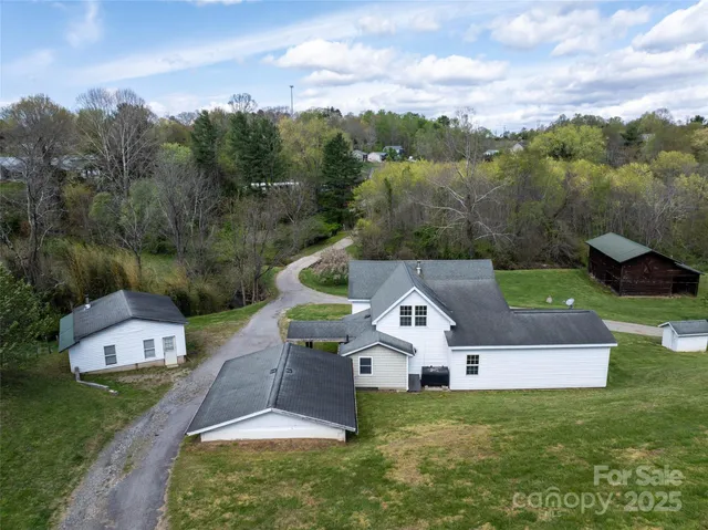 an aerial view of residential houses with outdoor space and trees