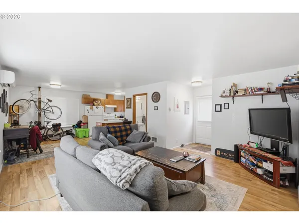 a living room with furniture a dining table and wooden floor
