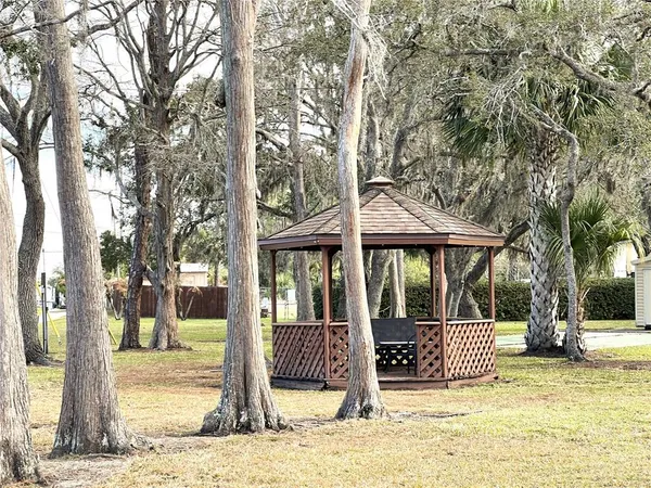 a front view of a house with a garden and trees