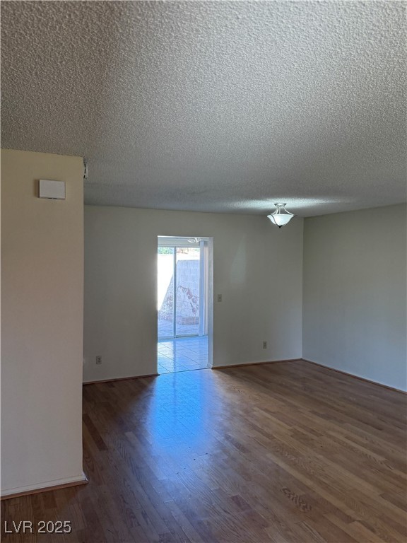 3367 Reka Street Las Vegas, NV 89121 - Photo 26 of 38 Unfurnished room featuring dark wood finished floors and a textured ceiling