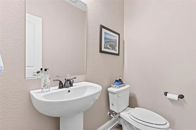 a bathroom with a sink mirror and toilet