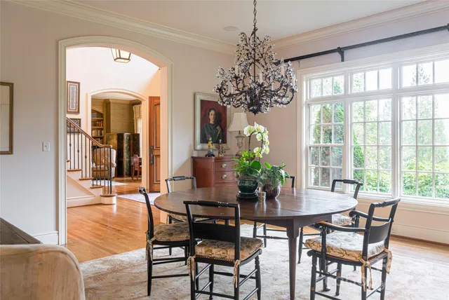 a dining room with furniture a chandelier and wooden floor