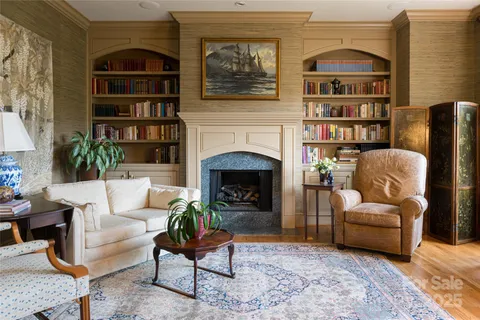 a living room with furniture a bookshelf and a fireplace