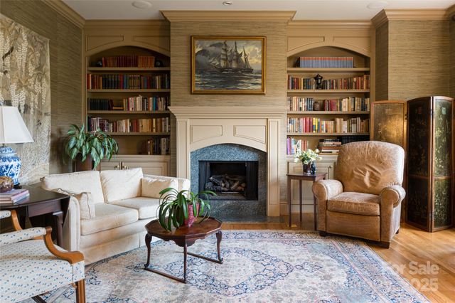 a living room with furniture a bookshelf and a fireplace
