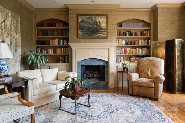 a living room with furniture a bookshelf and a fireplace