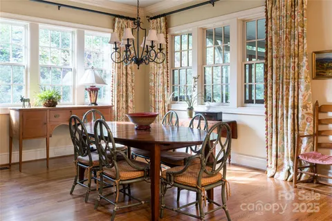 a dining room with furniture a chandelier and wooden floor