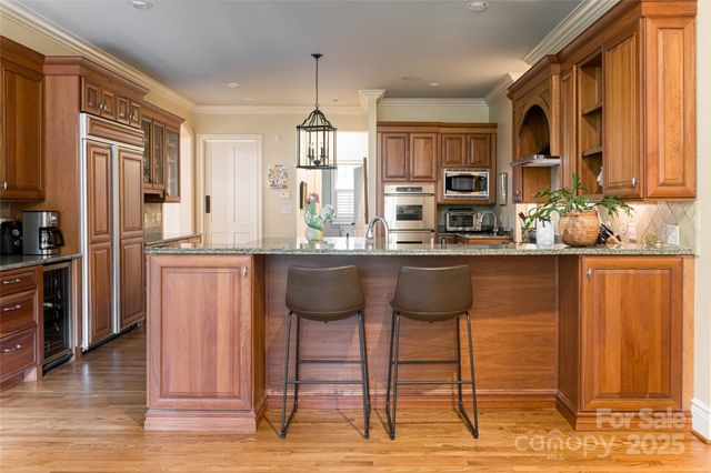 a kitchen with stainless steel appliances kitchen island granite countertop a refrigerator and a stove top oven