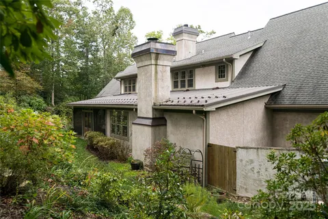 a view of a house with brick walls and a yard with plants