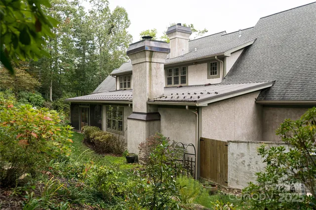 a view of a house with brick walls and a yard with plants
