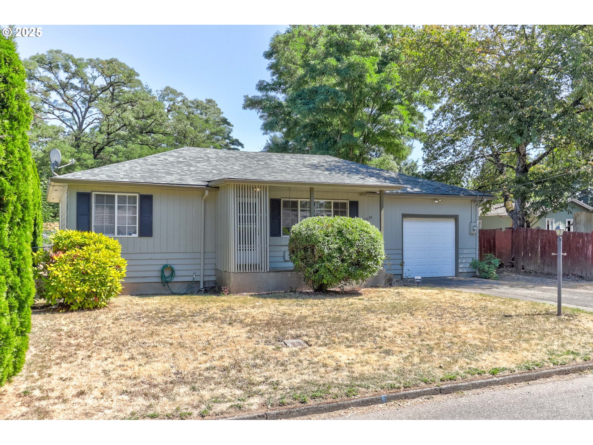 a view of a house with a yard and potted plants