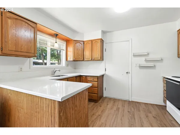 a kitchen with a wooden floor window and cabinets