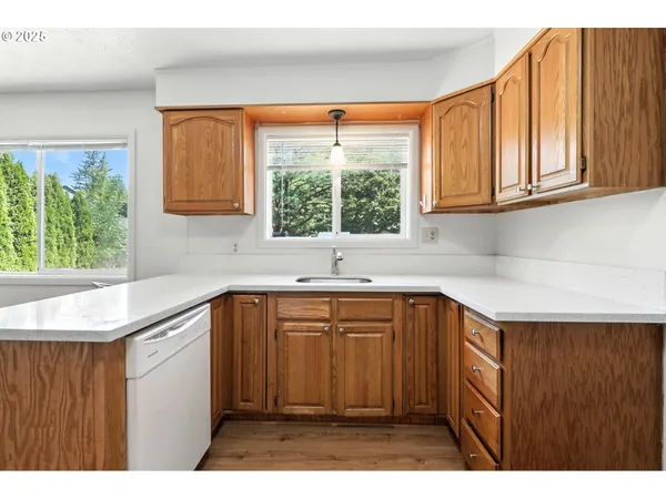 a kitchen with stainless steel appliances kitchen island a sink window and cabinets