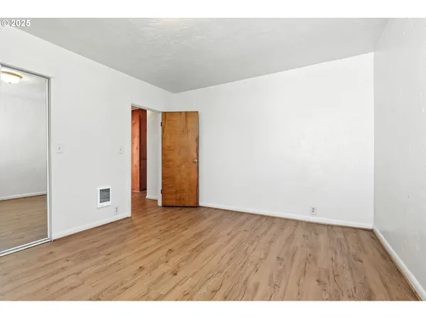 a view of an empty room with wooden floor