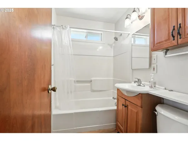 a bathroom with a sink vanity granite tub shower and a mirror