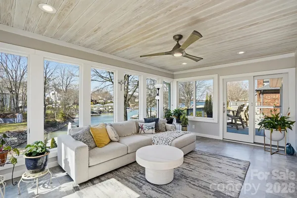 a living room with furniture and a large window with garden view