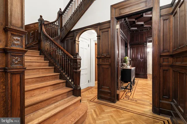 a view of a hallway with wooden floor and staircase