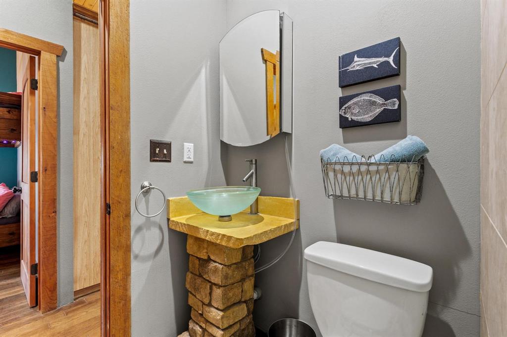 236 Homesite Road Pottsboro, TX 75076 - Photo 33 of 40 a bathroom with a granite countertop toilet sink and mirror