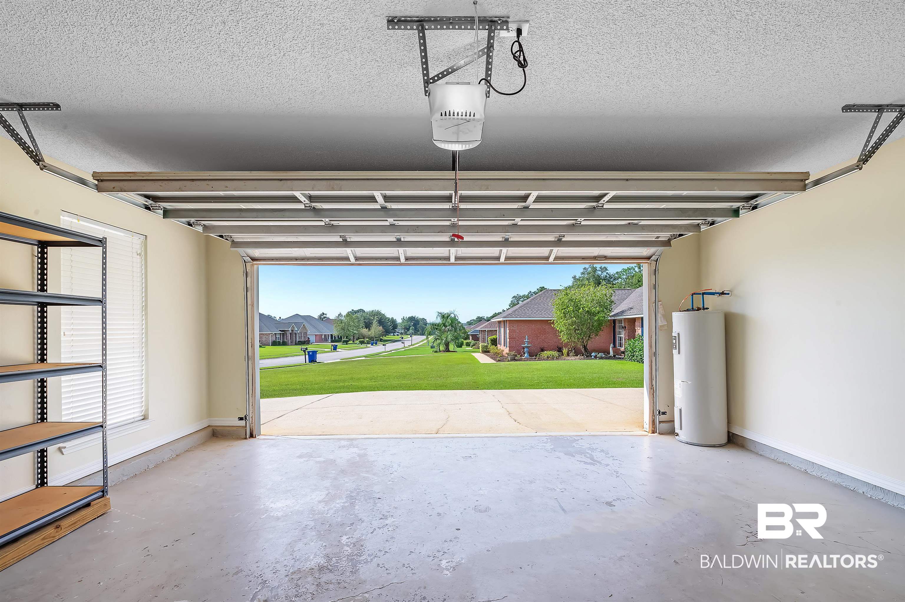 12443 Venice Boulevard Foley, AL 36535 - Photo 59 of 59 Garage featuring electric water heater, a garage door opener, and a lawn
